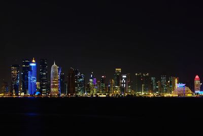 Illuminated cityscape against sky at night