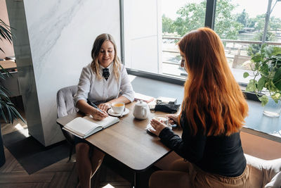 Young woman sitting on table at cafe