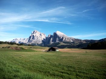 Scenic view of landscape and mountains against blue sky