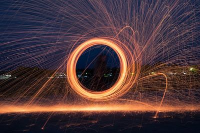 Wire wool spinning against sky at night