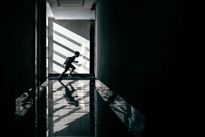 Side view of boy running in corridor
