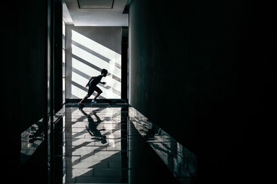 Silhouette man walking in corridor of building