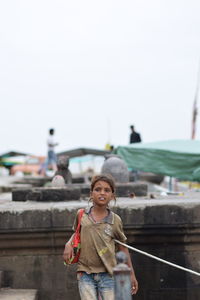 Portrait of smiling boy standing against clear sky