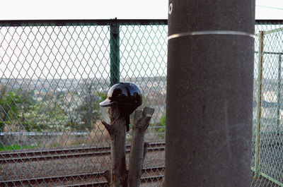 Rear view of man standing on chainlink fence