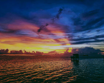 Scenic view of sea against dramatic sky during sunset
