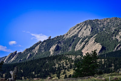 Low angle view of mountain against blue sky