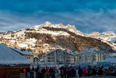 Group of people on snowcapped mountain against sky