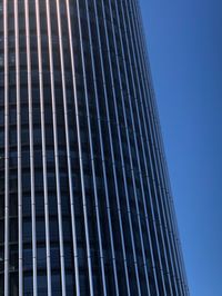 Low angle view of modern building against clear blue sky