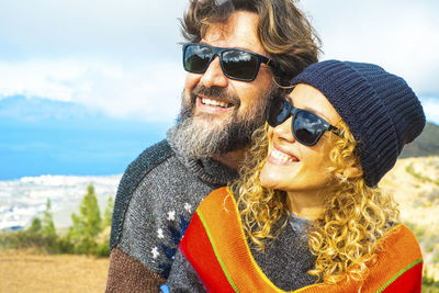 Portrait of woman wearing sunglasses while standing at beach