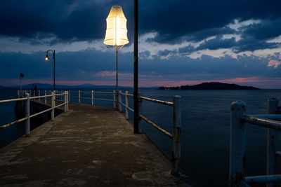 Pier over sea against sky at sunset