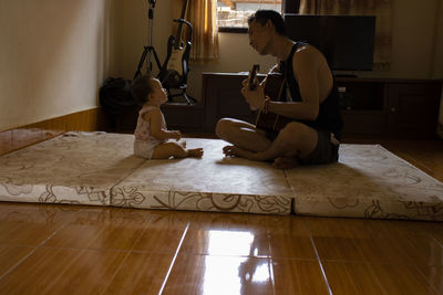 Man and baby sitting in floor