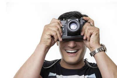 Portrait of man photographing against white background