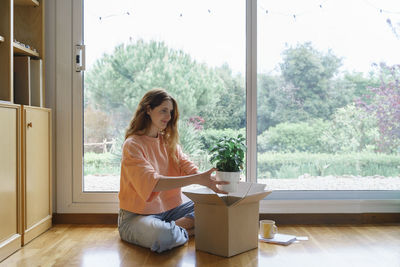Woman sitting by window at home