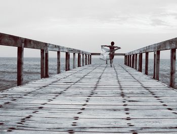 Rear view of woman walking on pier