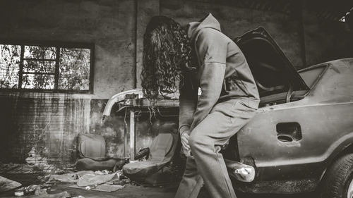 Man sitting in abandoned car