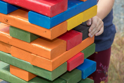 Cropped image of girl playing with colorful wooden blocks at playground