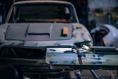 Hammer on shelf against car at garage