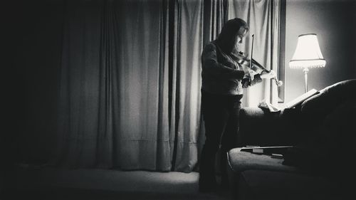 Woman playing violin indoors