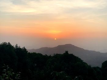 Scenic view of silhouette mountains against sky at sunset