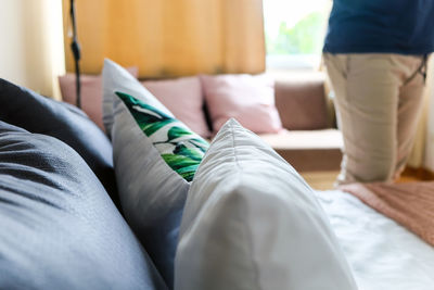 Low section of man relaxing on bed at home