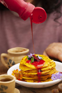Close-up of hand holding ice cream cone on table