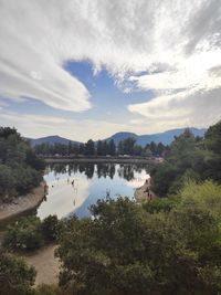 Scenic view of lake by trees against sky