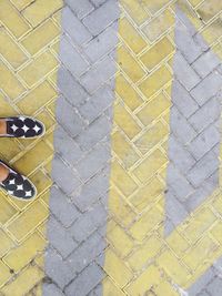 Low section of yellow shoes on footpath