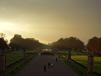 People in park against sky during sunset