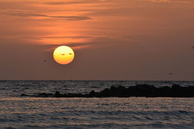 Scenic view of sea against orange sky