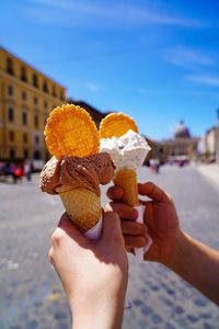 Two hands holding ice cream cone in the sun