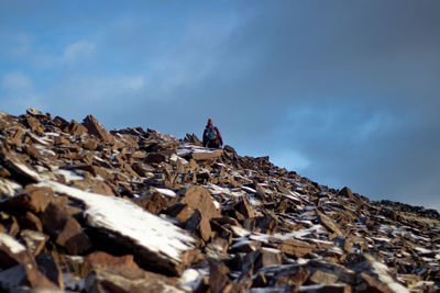 Rocky mountain peak scaled by hiker with striking blue sky in winter