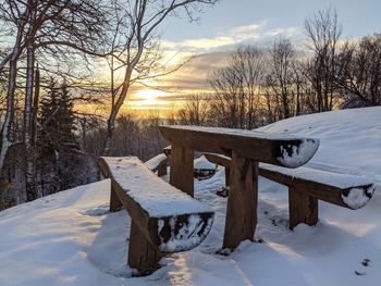 Scenic view of snow covered field against sky during sunset
