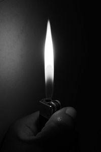 Close-up of hand holding lit candle