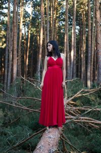 Mid adult woman standing on fallen tree in forest