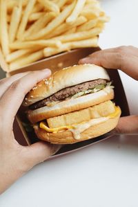Close-up of hands holding burger
