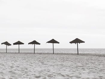 Deck chairs on beach against clear sky