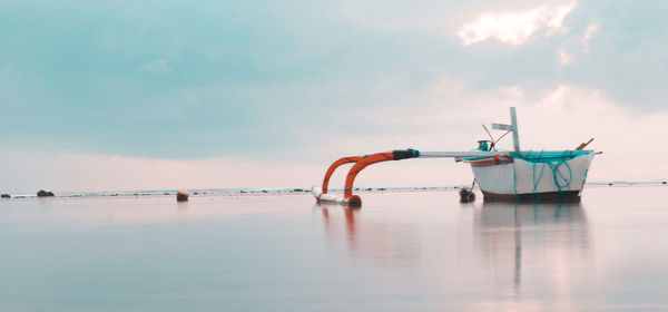 Fishing boat in sea against sky