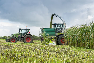 Tractor on agricultural field against sky