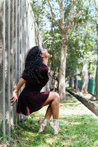 Woman sitting on tree trunk