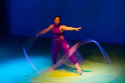 Blurred motion of man dancing against blue sky