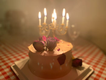 Close-up of burning candles on table