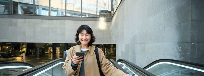 Low angle view of young woman standing in car