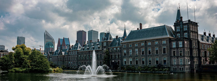 Panoramic view of buildings against cloudy sky