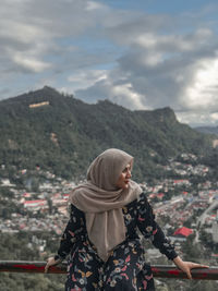 Full length of woman standing on mountain against sky