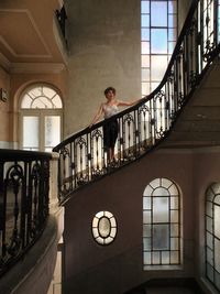 Low angle view of woman standing by railing