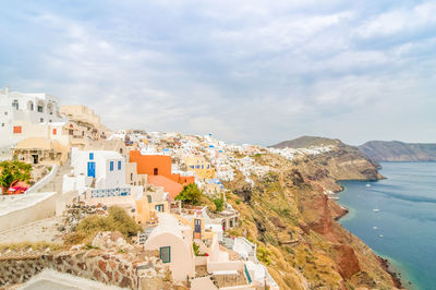 High angle view of townscape by sea against sky