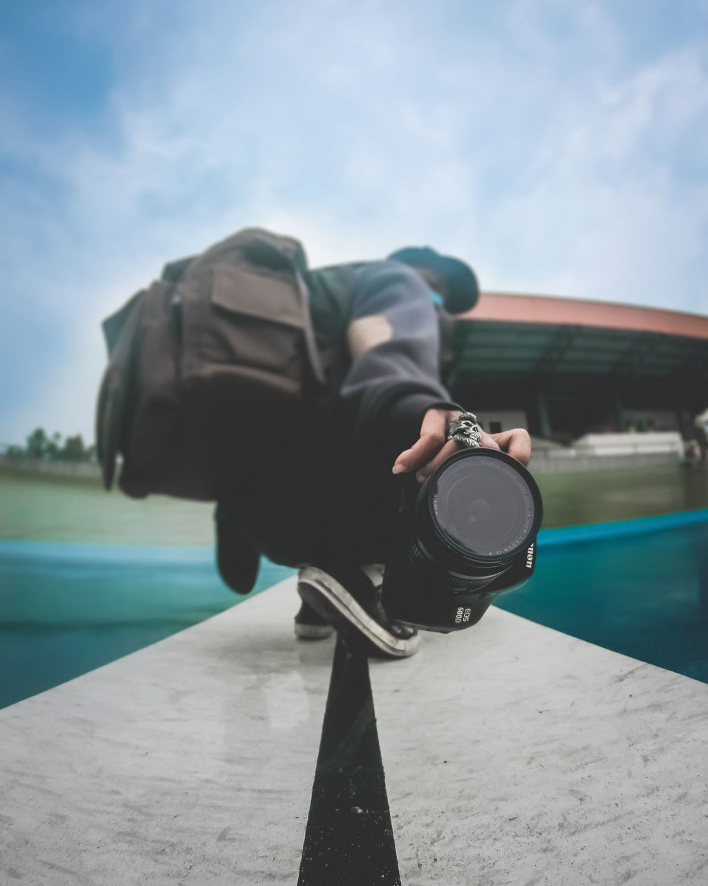 LOW SECTION OF MAN PHOTOGRAPHING IN SWIMMING POOL