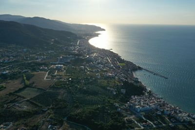High angle view of townscape by sea against sky