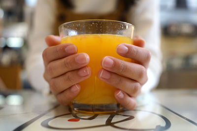 Close-up of hand holding glass of juice