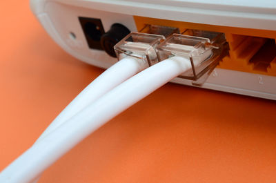Close-up of cables in router on orange background